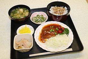 社員食堂で提供されている煮込みハンバーグなどの料理の写真