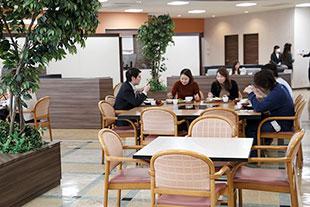 自社製品を使った綺麗な食堂内で昼食を取る社員たちの写真
