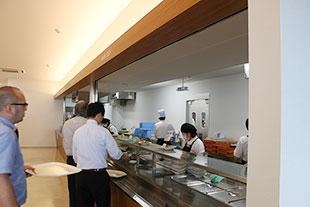 食堂でトレーを持ち並ぶ社員の方々の写真