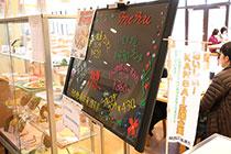 食堂においてあるボード横に飾られている「おいしい！KANSAI応援企業」のノボリの写真
